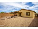 Expansive backyard featuring desert landscaping, a cozy firepit area, and a covered patio, perfect for outdoor enjoyment at 44944 W Miramar Rd, Maricopa, AZ 85139