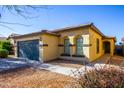 Beautiful single-story home featuring a two-car garage, stucco facade, and well-manicured landscaping at 44944 W Miramar Rd, Maricopa, AZ 85139