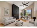 Bright living room features modern fireplace, vaulted ceilings, ceiling fan, and views of backyard at 4753 E Bighorn Ave, Phoenix, AZ 85044