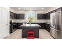 Modern kitchen with stainless steel appliances, dark cabinets, and a center island at 4901 S Turbine --, Mesa, AZ 85212
