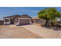 Single-story home with a 2-car garage, xeriscaped yard and a driveway, perfect for low-maintenance living at 719 E Broadway Ave, Apache Junction, AZ 85119