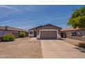 Single-story home boasts a large driveway, desert landscaping, neutral tones, and attached two-car garage at 719 E Broadway Ave, Apache Junction, AZ 85119