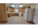 Well-lit kitchen equipped with a white refrigerator, ample cabinet space, and laminate countertops at 719 E Broadway Ave, Apache Junction, AZ 85119