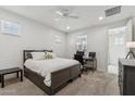 Neutral bedroom with a ceiling fan, carpet flooring, a grey bed frame, and two windows at 732 W Flintlock Way, Chandler, AZ 85286
