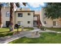 Exterior view of a two story condo with a grill, bench, and lawn at 750 E Northern Ave # 2143, Phoenix, AZ 85020