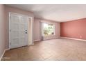 Spacious living room featuring neutral paint, tile floors, and a large window providing natural light at 8238 E Jackrabbit Rd, Scottsdale, AZ 85250