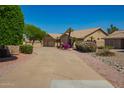 Lovely single-story tan home with three-car garage and colorful desert landscaping at 8627 W Morrow Dr, Peoria, AZ 85382