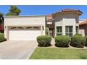Charming single-story home featuring a well-manicured lawn, stucco exterior, and a two-car garage at 9484 N 105Th Pl, Scottsdale, AZ 85258