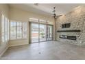 Open living room with stone fireplace and sliding glass doors to backyard at 9562 E Cavalry Dr, Scottsdale, AZ 85262
