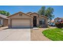 Welcoming single-story home with a two-car garage and attractive desert landscaping on a sunny day at 10649 W Alvarado Rd, Avondale, AZ 85392