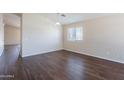 A well-lit living room featuring laminate wood flooring and a neutral color scheme to personalize and enjoy at 10649 W Alvarado Rd, Avondale, AZ 85392