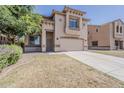 Inviting two-story home with a desert landscape, wide driveway, and attached two-car garage at 11016 W Griswold Rd, Peoria, AZ 85345