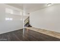 Open-concept living room with dark floors and an adjacent staircase at 11016 W Griswold Rd, Peoria, AZ 85345