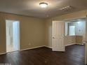 Spacious bedroom with dark floors featuring an ensuite bathroom and walk-in closet at 11016 W Griswold Rd, Peoria, AZ 85345
