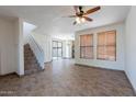 Open living space with staircase, tile flooring, ceiling fan, and backyard view at 1244 S Tacoma --, Mesa, AZ 85209
