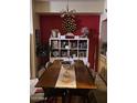 Cozy dining area with a wood table, bright red wall, and decorative shelving at 14950 W Mountain View Blvd # 5303, Surprise, AZ 85374