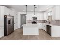Bright kitchen featuring white cabinets, a center island, stainless steel appliances, and modern pendant lighting at 18486 E Dario Rd, Gold Canyon, AZ 85118