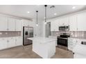Beautiful open kitchen with white cabinetry, a center island, stainless steel appliances, and stylish backsplash at 18486 E Dario Rd, Gold Canyon, AZ 85118