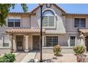 Inviting townhome featuring a light-colored exterior with arched window and tidy front garden at 1961 N Hartford St # 1055, Chandler, AZ 85225