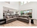 Open-concept floorplan with a large sofa, wood floors, and bright natural light at 20451 E Via De Colina --, Queen Creek, AZ 85142