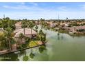 Lovely aerial view of a home on a waterway with well-maintained landscaping and a private dock at 2128 E Clipper Ln, Gilbert, AZ 85234
