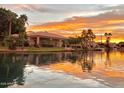 Waterfront home at sunset with lush landscaping and a boat dock for enjoying the serene lake at 2128 E Clipper Ln, Gilbert, AZ 85234