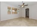 Bright living room with tile floors, multiple windows with blinds, and an arched doorway to the bathroom at 2475 E Vermont Dr, Gilbert, AZ 85295