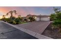 Lovely home with a brick driveway and attached garage with white garage doors framed by lush, mature landscaping at 2892 E Fruitvale Ave, Gilbert, AZ 85297