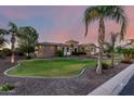 Beautiful stone home boasts a circular turret, expansive front lawn, and manicured landscaping at 2892 E Fruitvale Ave, Gilbert, AZ 85297