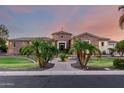 Gorgeous stone home featuring a circular turret, mature palm trees, and a welcoming paver walkway at 2892 E Fruitvale Ave, Gilbert, AZ 85297