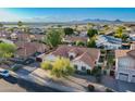 Aerial view of a single-Gathering home with red tile roof in a community near the mountains and a lake at 3058 E Nance St, Mesa, AZ 85213