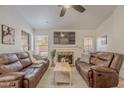 Cozy living room with fireplace, mounted TV, and comfortable leather couches creating a welcoming atmosphere at 3058 E Nance St, Mesa, AZ 85213
