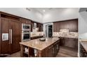 Gourmet kitchen with stainless steel appliances, a large island, and custom cabinetry at 320 N Portland Ave, Gilbert, AZ 85234