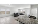 Bright living room featuring neutral tile flooring, modern gray furniture, and plenty of natural light from large windows at 38099 N Stallion St, San Tan Valley, AZ 85140