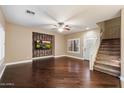 Open-concept living area with hardwood floors, a decorative fireplace, and a staircase at 3932 S Crosscreek Dr, Chandler, AZ 85286