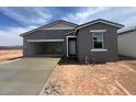 Single story home with gray exterior, concrete driveway, and an attached two car garage at 47451 W Kenner Dr, Maricopa, AZ 85139