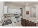 Bright kitchen featuring white cabinets, granite countertops, and stainless steel appliances at 7130 E Laguna Azul Ave, Mesa, AZ 85209