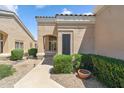 Beige single-story home featuring a covered front entrance and desert landscaping at 8426 W Utopia Rd, Peoria, AZ 85382