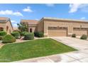 Beige single-story home featuring a three car garage and desert landscaping at 8426 W Utopia Rd, Peoria, AZ 85382