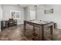 An inviting game room features a stylish pool table, a window with natural light, and modern decor at 15427 W Port Au Prince Ln, Surprise, AZ 85379