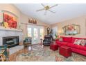 Cozy living room with fireplace, ceiling fan, and access to outdoor area with French doors at 17342 E Quail Ridge Dr, Fountain Hills, AZ 85268