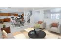 Bright living room features tile floors, a modern rug, open access to a kitchen and staircase at 1839 E Parkside Ln, Phoenix, AZ 85024