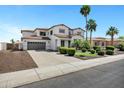 Charming two-story home with landscaped yard, palm trees, and a three car garage at 18429 W Mauna Loa Ln, Surprise, AZ 85388