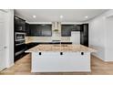 Modern kitchen featuring dark cabinets, granite countertops, stainless steel appliances and island with sink at 18950 W Stella Ave, Waddell, AZ 85355