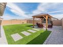 Inviting backyard with artificial turf, a gazebo, and a swing set at 19407 W Pierson St, Litchfield Park, AZ 85340