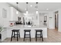 Bright kitchen featuring white cabinets, stainless steel appliances, and pendant lighting at 19407 W Pierson St, Litchfield Park, AZ 85340