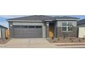 Charming single-story home featuring a gray exterior, gray garage door, and low maintenance landscaping at 25235 N 183Rd Dr, Wittmann, AZ 85361