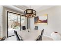 Dining area with modern lighting, a painting, and view of the lush desert landscape at 25555 N Windy Walk Dr # 64, Scottsdale, AZ 85255