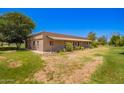 Side view of a charming ranch home with a covered porch and lush landscaping at 26232 S Lemon Ave, Queen Creek, AZ 85142