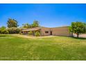 A single-story home with a front yard featuring green grass and mature trees at 26232 S Lemon Ave, Queen Creek, AZ 85142